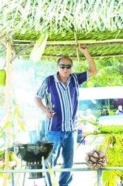 Top chef: Pico Seguenza enjoyed his grilling while riding the float during the parade at the Malojloj's San Isidro fiesta celebration. (Jonathan Abella/For Southern Weekly)